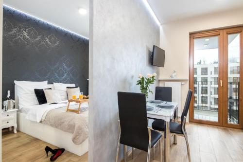een slaapkamer met een bed en een tafel met stoelen bij Angel Apartament in Krakau