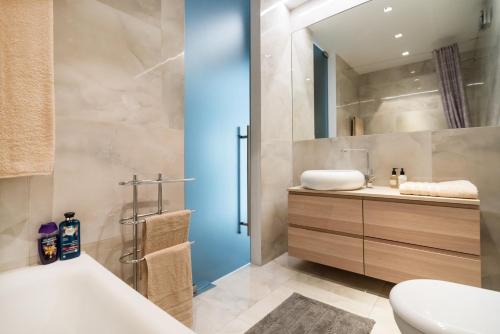 y baño con bañera, aseo y lavamanos. en Elegant Cozy Apartment, en Viena
