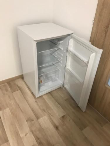 a white refrigerator with its door open in a room at Apartment Šarka in HoÅ¡Å¥ka