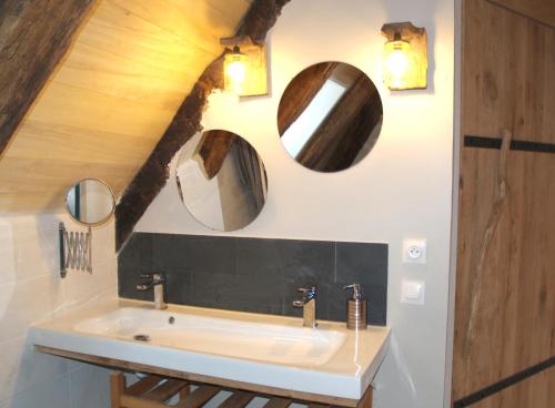 Un baño con un lavabo y dos espejos en la pared. en Gîte Nature Le moulin, en Vitrac-sur-Montane