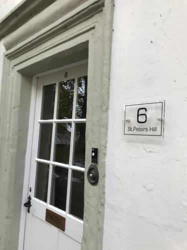 a door with a sign on the side of a building at Historic Grade II Listed Homely Cottage in Stamford