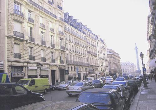 a busy city street with cars parked next to buildings at LOUVRE VENDOME with air conditionning in Paris