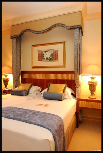 a hotel room with two beds and two lamps at Peermont D'oreale Grande at Emperors Palace in Kempton Park