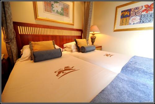 a hotel room with two beds with logos on them at Peermont D'oreale Grande at Emperors Palace in Kempton Park