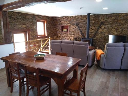 uma sala de estar com uma mesa de madeira e um sofá em Casa de Xisto Ti Lucília em Videmonte