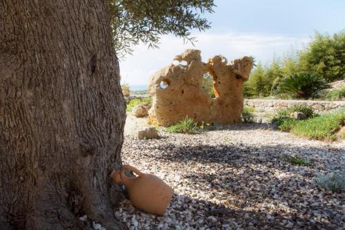a clay pot sitting next to a tree at Le Gioie - Villa Macchia Mediterranea - Splendida villa vista mare immersa nel verde in Torre Pali 