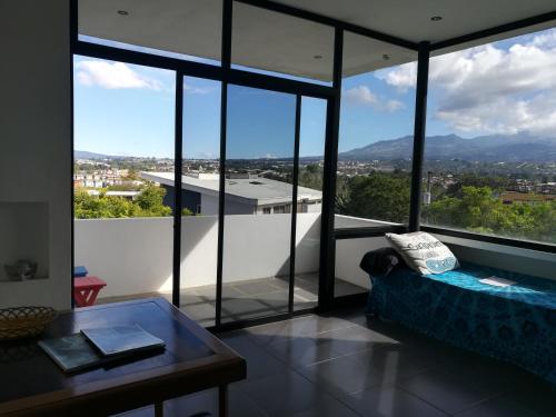 a living room with a couch and large windows at Casa Marlui-San José in Curridabat