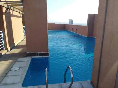 a swimming pool on top of a building with blue water at Departamento Santiago Centro Full Equipado in Santiago