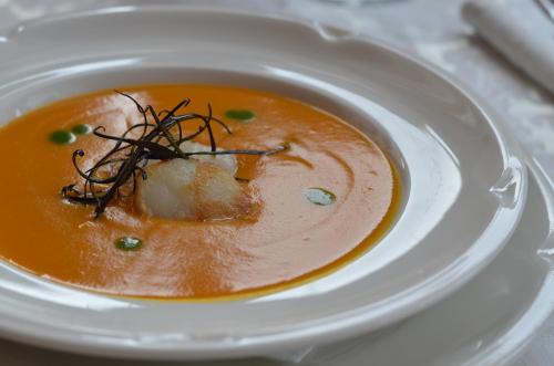 a bowl of soup on a white plate at Hotel Cristallo in Andalo