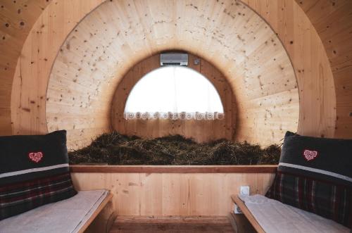 a small room with a window with a pile of hay at Hotel Cristallo in Andalo