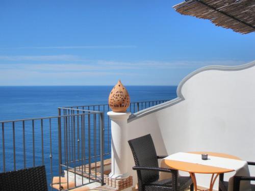 a balcony with a table and chairs and the ocean at Amalfi Residence in Conca dei Marini