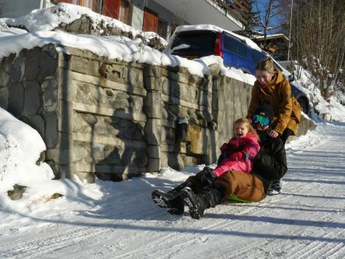 a woman and a child sitting in the snow at Viosia-Ost in Fiesch