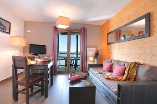 a living room with a couch and a table and a desk at Résidence Le Pic de l'Ours in Font-Romeu