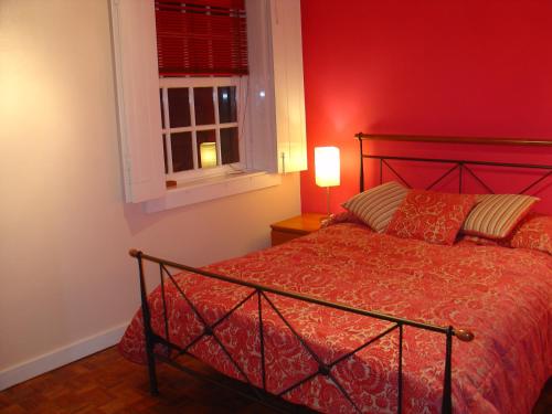 um quarto vermelho com uma cama e uma janela em Historic Oporto Apartment at oporto UNESCO area, in front of Porto Wine caves em Porto