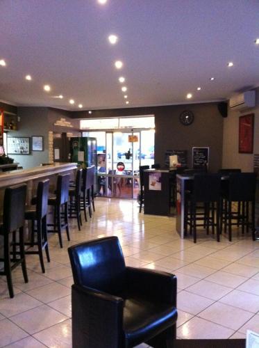 un restaurant avec des chaises et un bar avec un comptoir dans l'établissement L'Avenue, à Agde