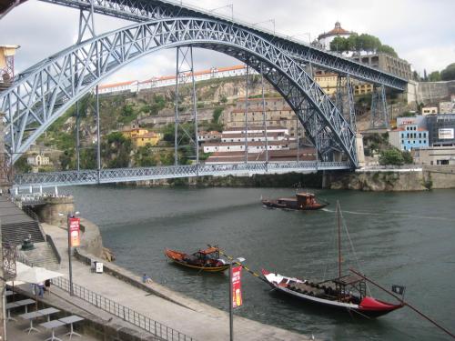 two boats in the water under a bridge at Historic Oporto Apartment at oporto UNESCO area, in front of Porto Wine caves in Porto