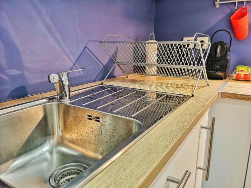 - un évier de cuisine avec un étendoir à vaisselle sur le comptoir dans l'établissement Au p'tit Cordonnier, à Colmar