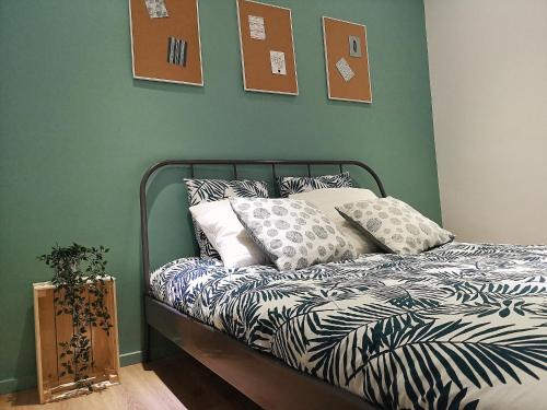 une chambre avec un lit avec des oreillers dessus dans l'établissement Au p'tit Cordonnier, à Colmar