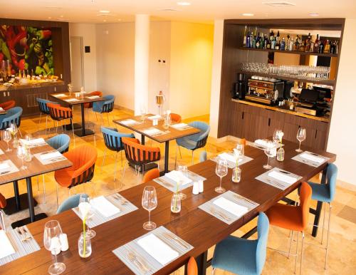 a restaurant with tables and chairs and a bar at Hotel Estelar San Isidro in Lima