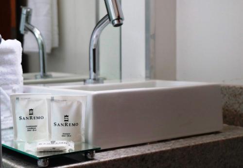 a bathroom sink with two candles on a counter at Hotel San Remo in Jequié