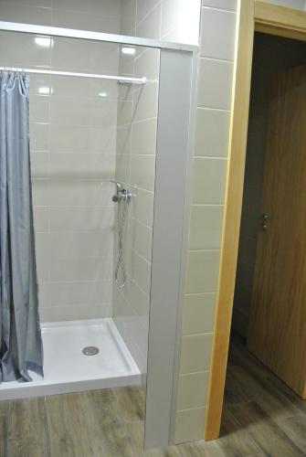 a bathroom with a shower with a glass door at Hostel Criativo do Sabugueiro in Sabugueiro