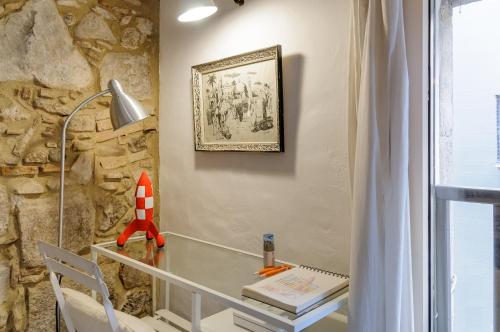 - un bureau en verre dans une chambre dotée d'un mur en pierre dans l'établissement Bravissimo Old Side Girona Two, centre Barri Vell, à Gérone