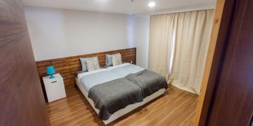 a bedroom with a bed with a wooden headboard at Hakuba Powder Cottage Crystal in Hakuba