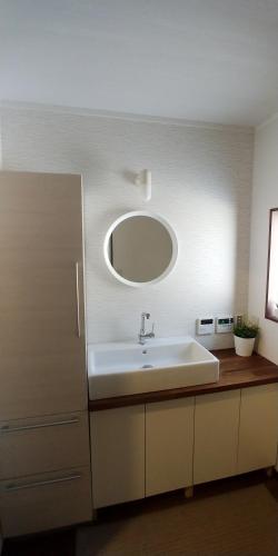 a bathroom with a sink and a mirror at Hakuba Powder Cottage Crystal in Hakuba