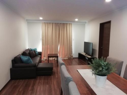 ein Wohnzimmer mit Sofa und Fernseher in der Unterkunft Hakuba Powder Cottage Crystal in Hakuba