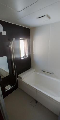 a small room with a bed and a window at Hakuba Powder Cottage Crystal in Hakuba