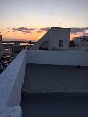 a view of a building with the sunset in the background at Casa Tradicional Algarvia - Rooms in Faro