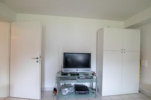 Una televisión o centro de entretenimiento en Big 1 Room Apartment - 15 Min Messe DUS