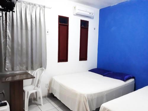 Pokój z 2 łóżkami i niebieską ścianą w obiekcie Pousada Lunar w mieście Parnaíba