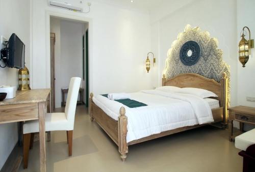 una camera da letto con un letto, un tavolo e una scrivania di Rumah Jawa Guest House (Syariah) a Yogyakarta