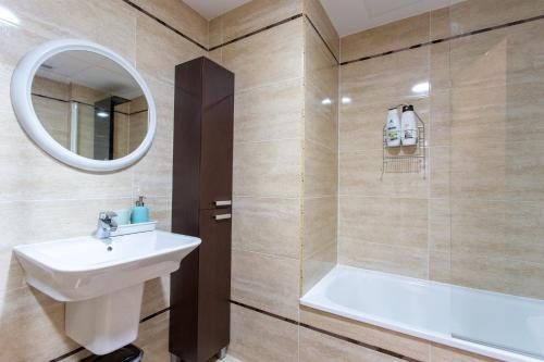 uma casa de banho com um lavatório, um chuveiro e um espelho. em Apartment on the beach,pool,WiFi,garage,Valencia em Valência