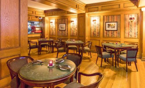 a restaurant with wooden walls and tables and chairs at Hotel Frontera Clásico in Temuco