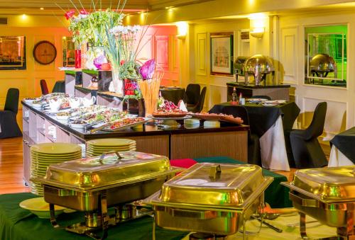 a buffet line with trays of food in a restaurant at Hotel Frontera Clásico in Temuco