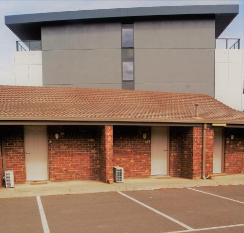 a brick building with two white doors and a parking lot at Quality Hotel Lakeside in Bendigo