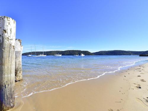 a sandy beach with boats in the water at Oceans Eleven at Iluka Resort Apartments in Palm Beach