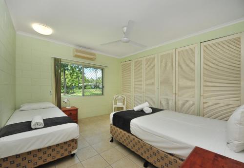 a bedroom with two beds and a window at Seascape Holidays - 53 Reef Street in Port Douglas
