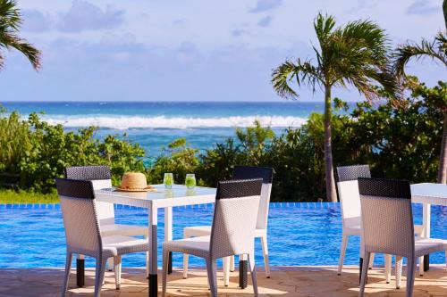 a table and chairs with a view of the ocean at Allamanda Imgya Coral Village in Miyako-jima