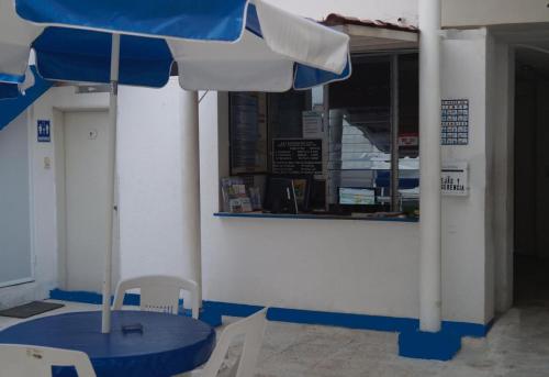 a table with an umbrella in front of a restaurant at HOTEL PARAISO ACAPULCO in Acapulco