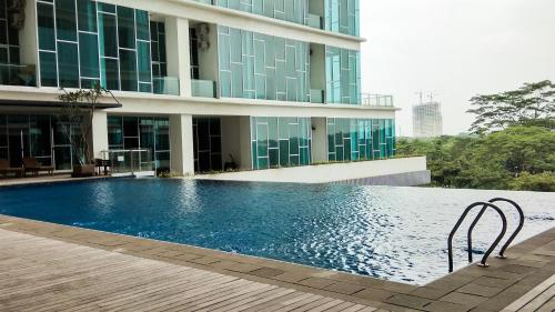 a swimming pool in front of a building at 1BR Brooklyn Alam Sutera Apartment near BINUS By Travelio in Dongkal Dua