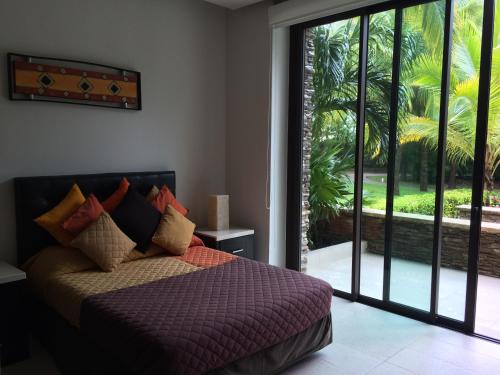 a bedroom with a bed and a large sliding glass door at La Isla Gran Cayman 904 in Acapulco