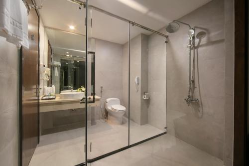 a bathroom with a glass shower and a toilet at Ha Long Marina Hotel in Ha Long
