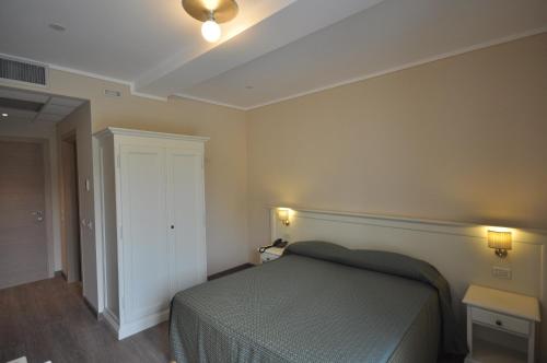 a bedroom with a bed and two lights on the wall at Hotel Panoramica in Salò