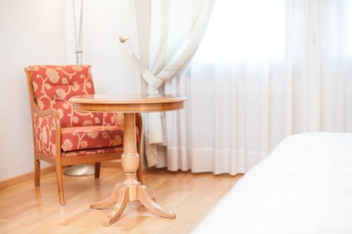 a table and a chair in a bedroom at Business Resort Parkhotel Werth in Bolzano