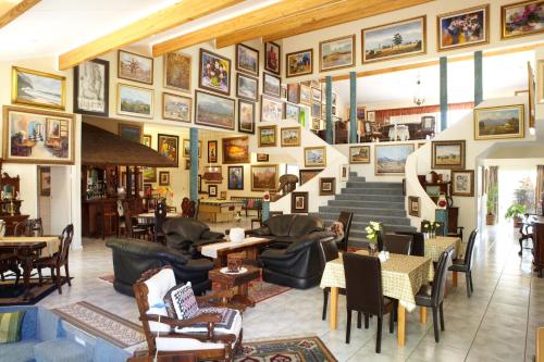 a lobby with chairs and tables and pictures on the wall at 7 Eland Boutique Guest House in Ladismith