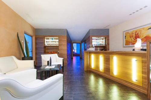 a living room with white chairs and a table at Business Resort Parkhotel Werth in Bolzano