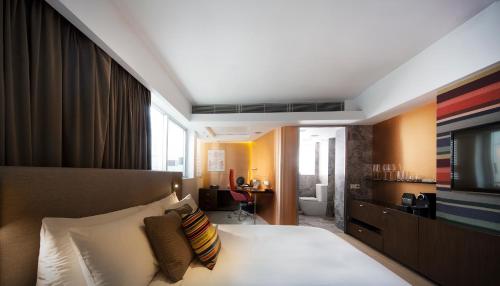 a hotel room with a bed and a television at Ovolo Central in Hong Kong
